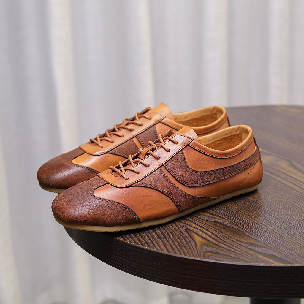 Brown leather low-top sneakers with lace-up front and side panels, cushioned sole