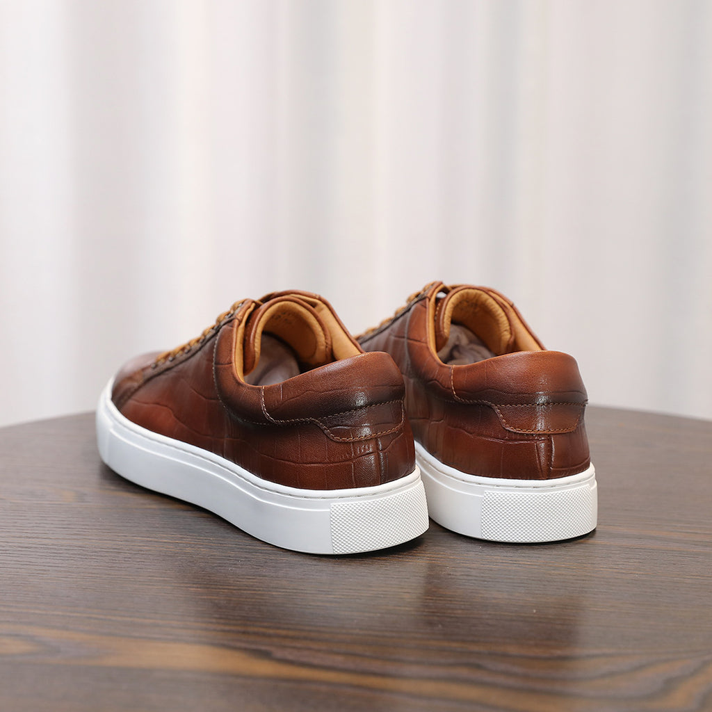 Men's brown leather sneakers, rear view with white rubber sole and cushioned collar