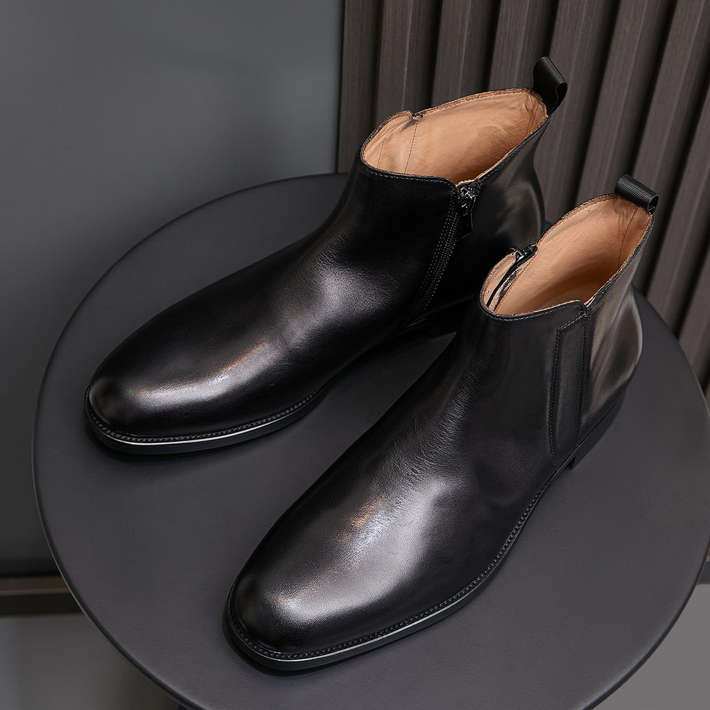 Black leather side-zip dress boots with pointed toes, angled view pair