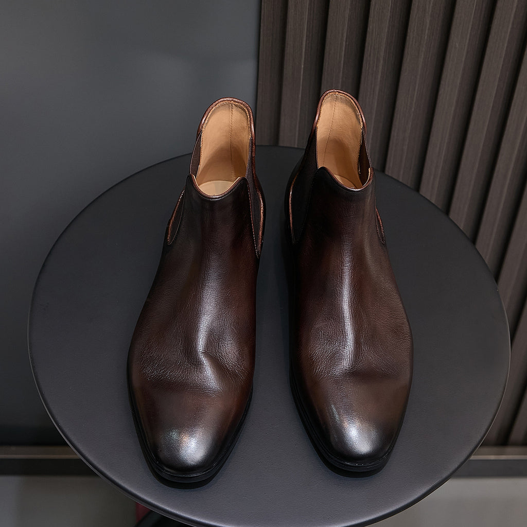 Dark brown suede Chelsea dress boots, front view with pointed toe and cushioned lining