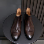 Dark brown suede Chelsea dress boots, front view with pointed toe and cushioned lining