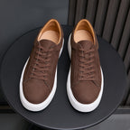 Men's dark brown leather sneakers, lace-up front view with white sidewall