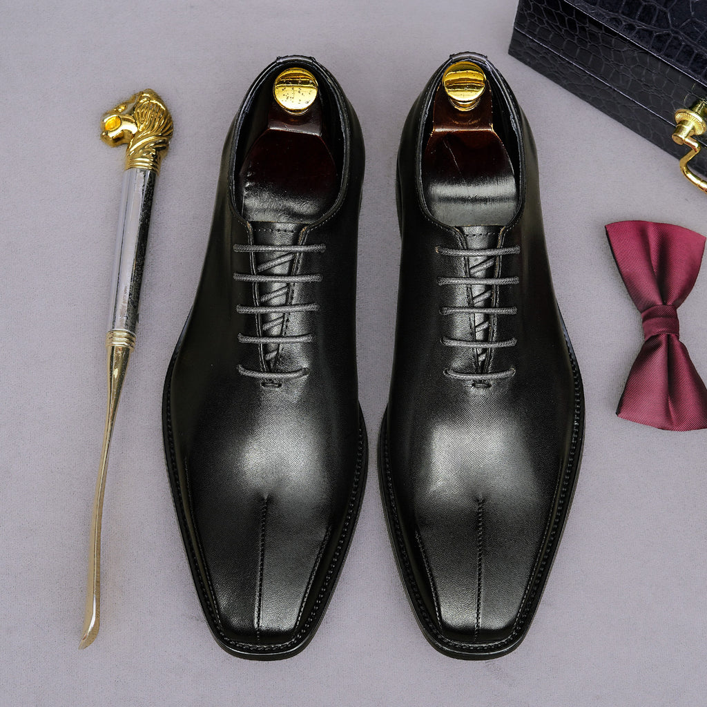 Men's black wingtip brogue oxfords, top view with lace-up details