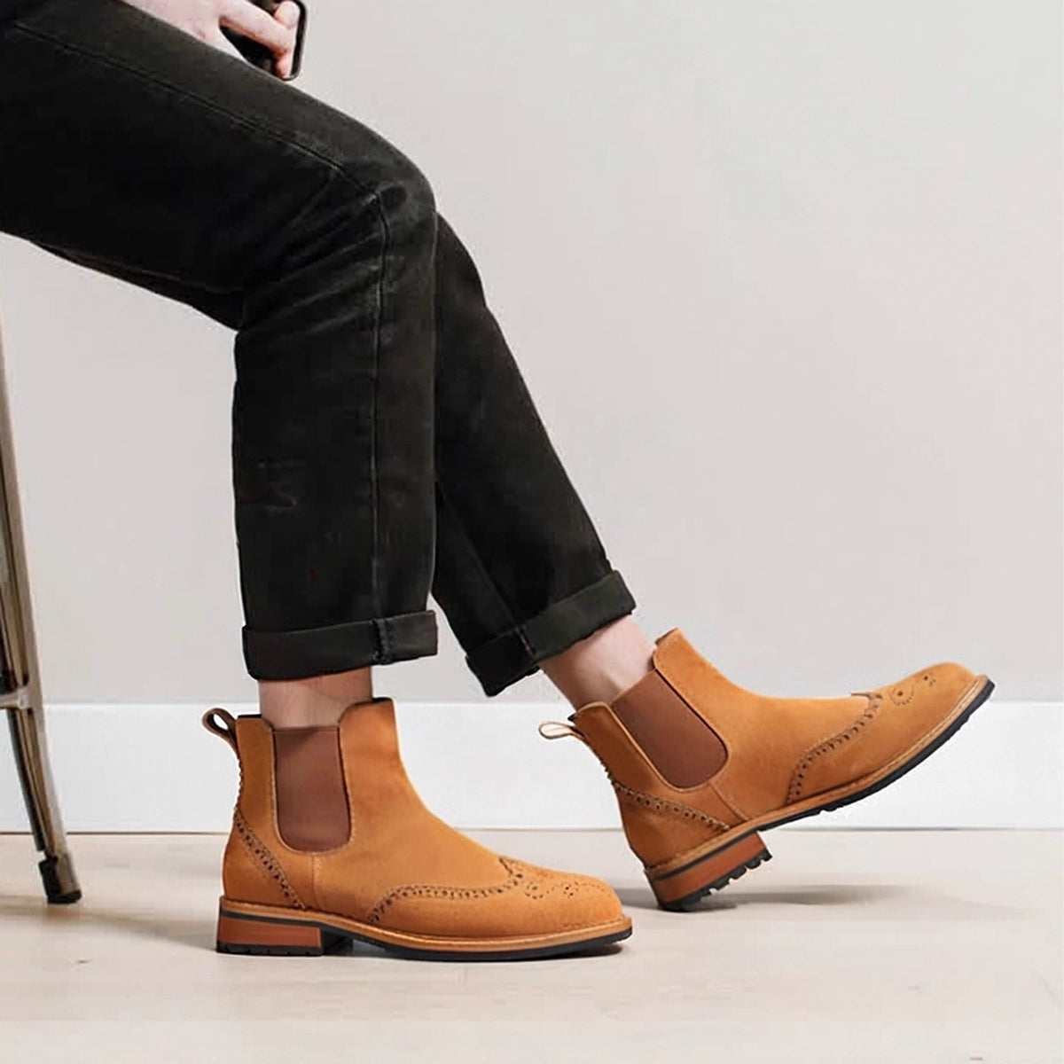 Tan suede pointed-toe Chelsea boots on model with elastic side panels and dark sole