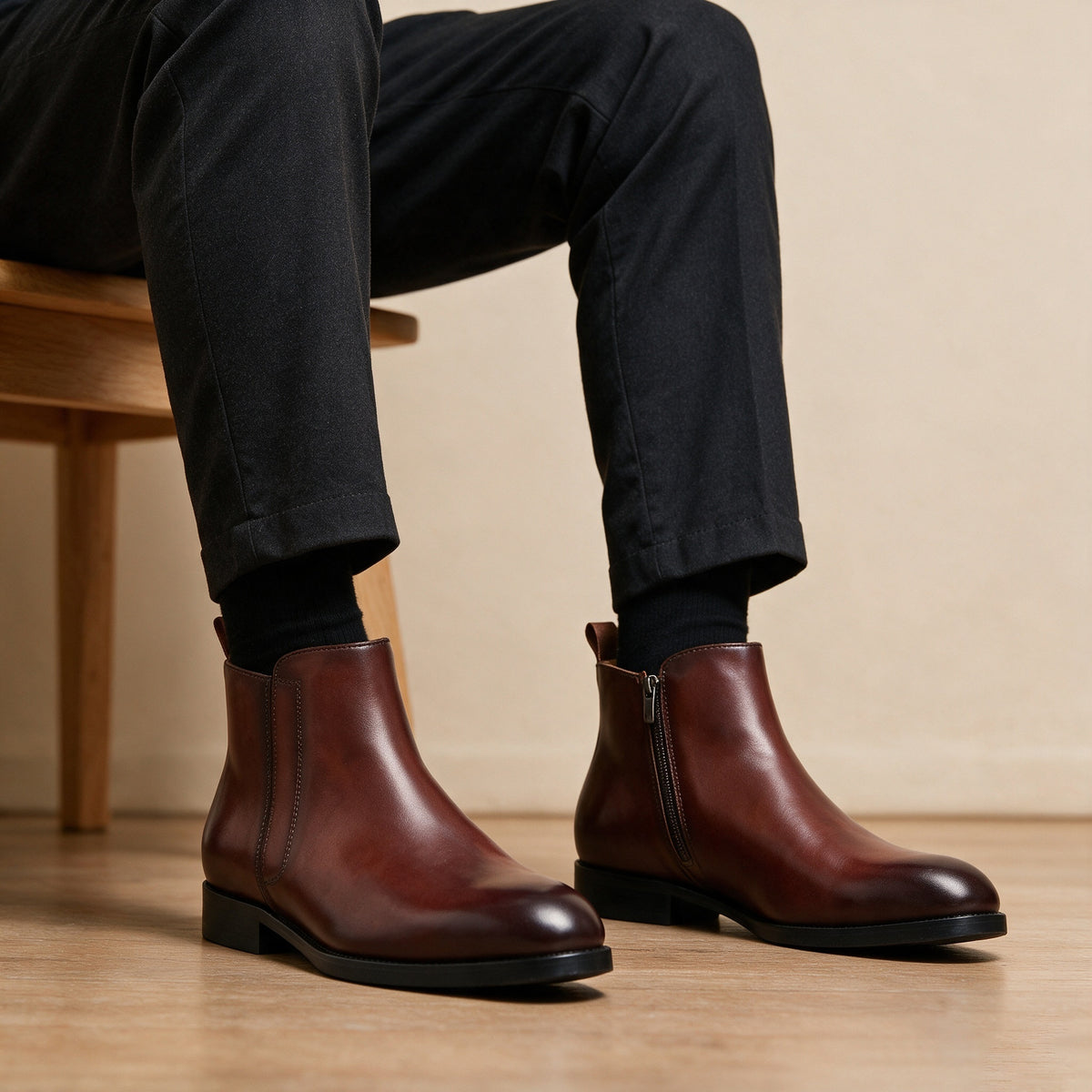 Pointed-toe leather side-zip dress boots in brown, side view with cuffed jeans