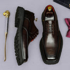 Men's chunky lug-sole wingtip brogue oxford shoes, dark color, side and front views.