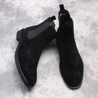 Black suede Chelsea dress boots pair, slip-on design with stitched upper panels