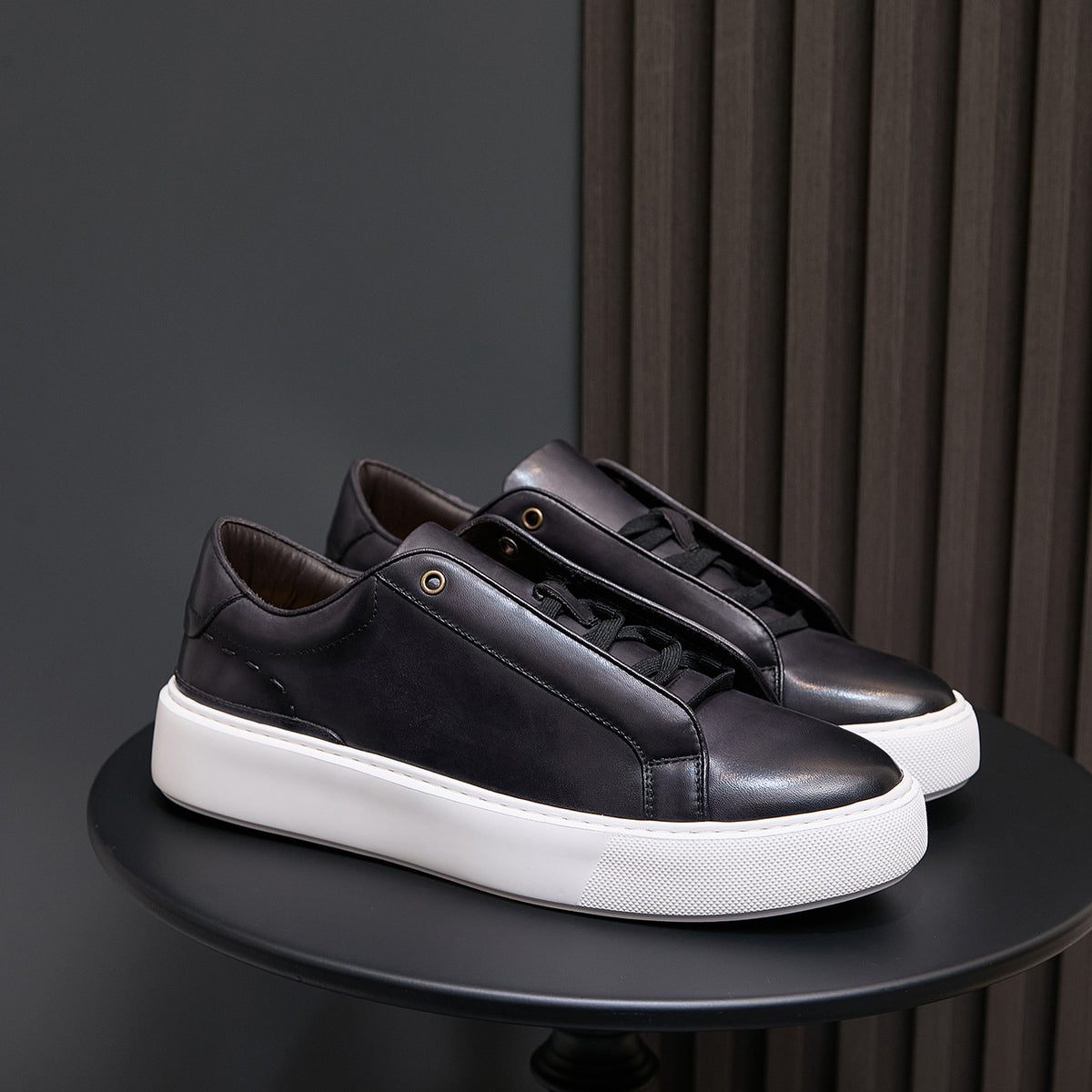 Men's black leather sneakers with lace-up closure and white sidewall sole
