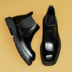 Men's black leather chelsea dress boots with elastic side panels and thick lug sole
