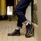 Black leather pointed-cap toe side-zip boots with laces and dark jeans