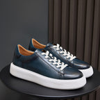 Men's blue leather lace-up sneakers with white rubber sole and clean minimalist panels