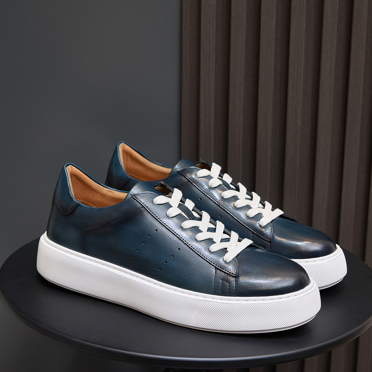 Men's blue leather lace-up sneakers with white rubber sole and clean minimalist panels