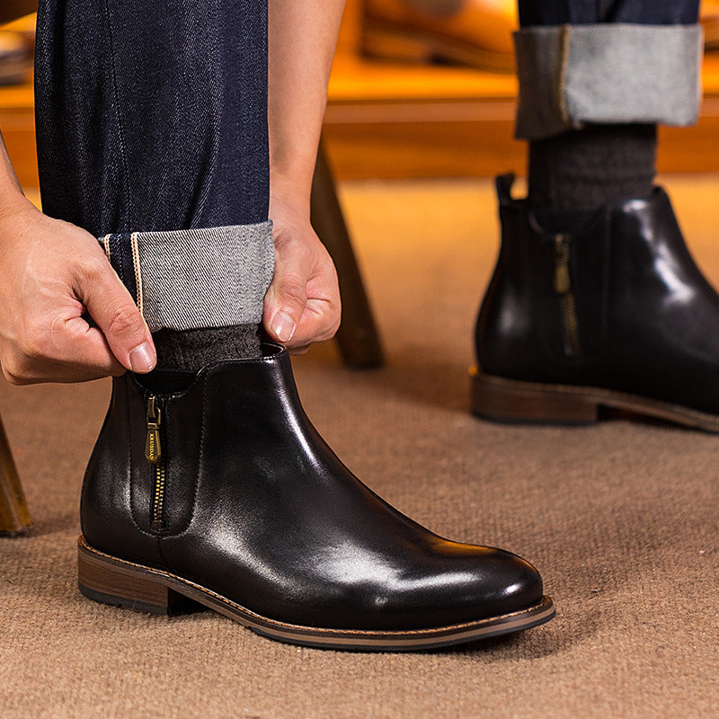 Black leather pointed-toe side-zip dress boot with tan trim; worn with dark pants