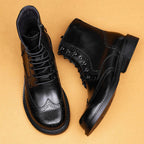Pair of black leather lace-up boots with wingtip perforations and chunky outsole