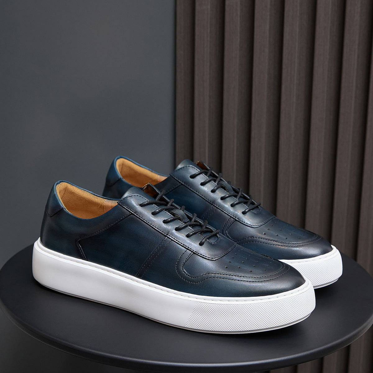 Leather sneakers, dark blue-green, lace-up front with white rubber sole.