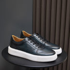 Men's dark leather low-top sneakers with black laces and textured white platform sole