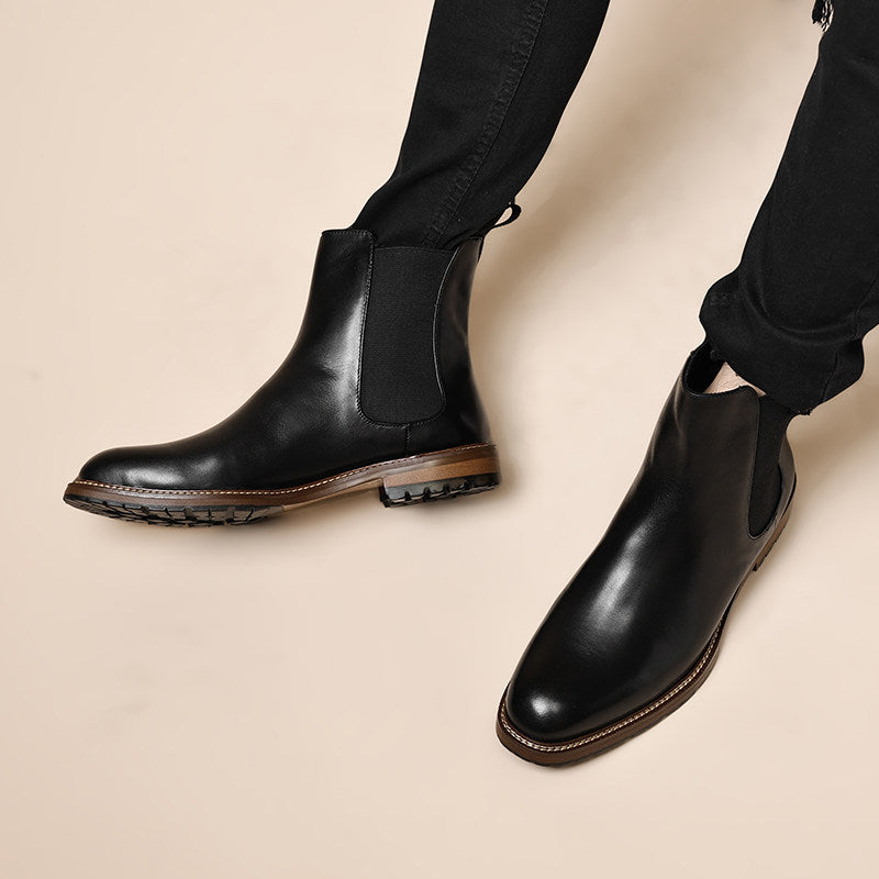 Black leather Chelsea boots worn with black pants, elastic side panels