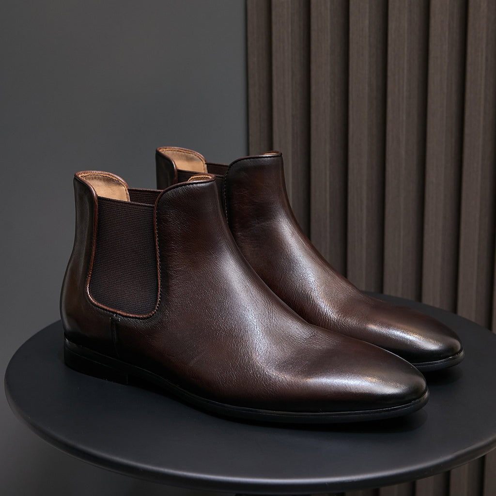 Dark brown pointed-toe Chelsea dress boots with elastic side panels and flat sole