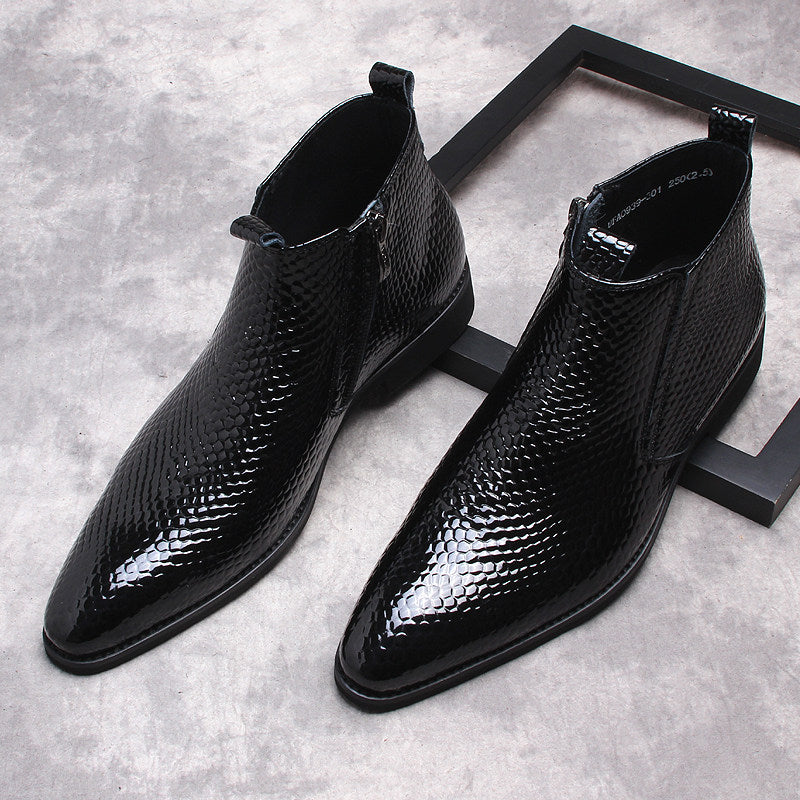Black patterned leather side-zip ankle boots with thick soles, two-quarter view.