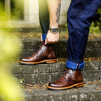Men's brown leather chukka boots with plain toe and lace-up front, tan sole trim