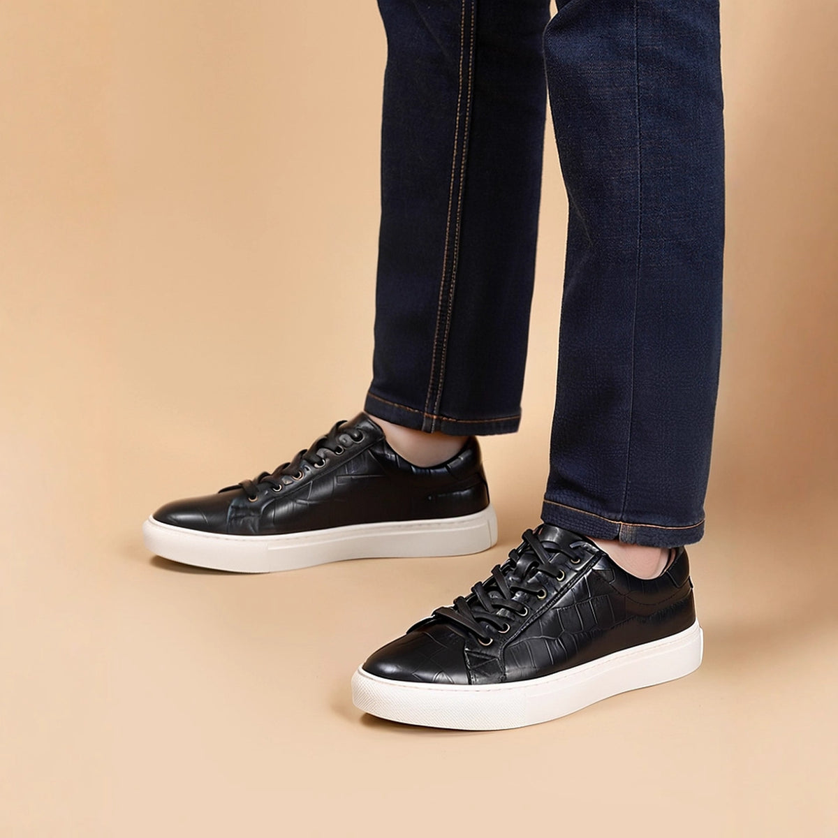 Men's black leather lace-up sneakers on feet with low-profile white sole