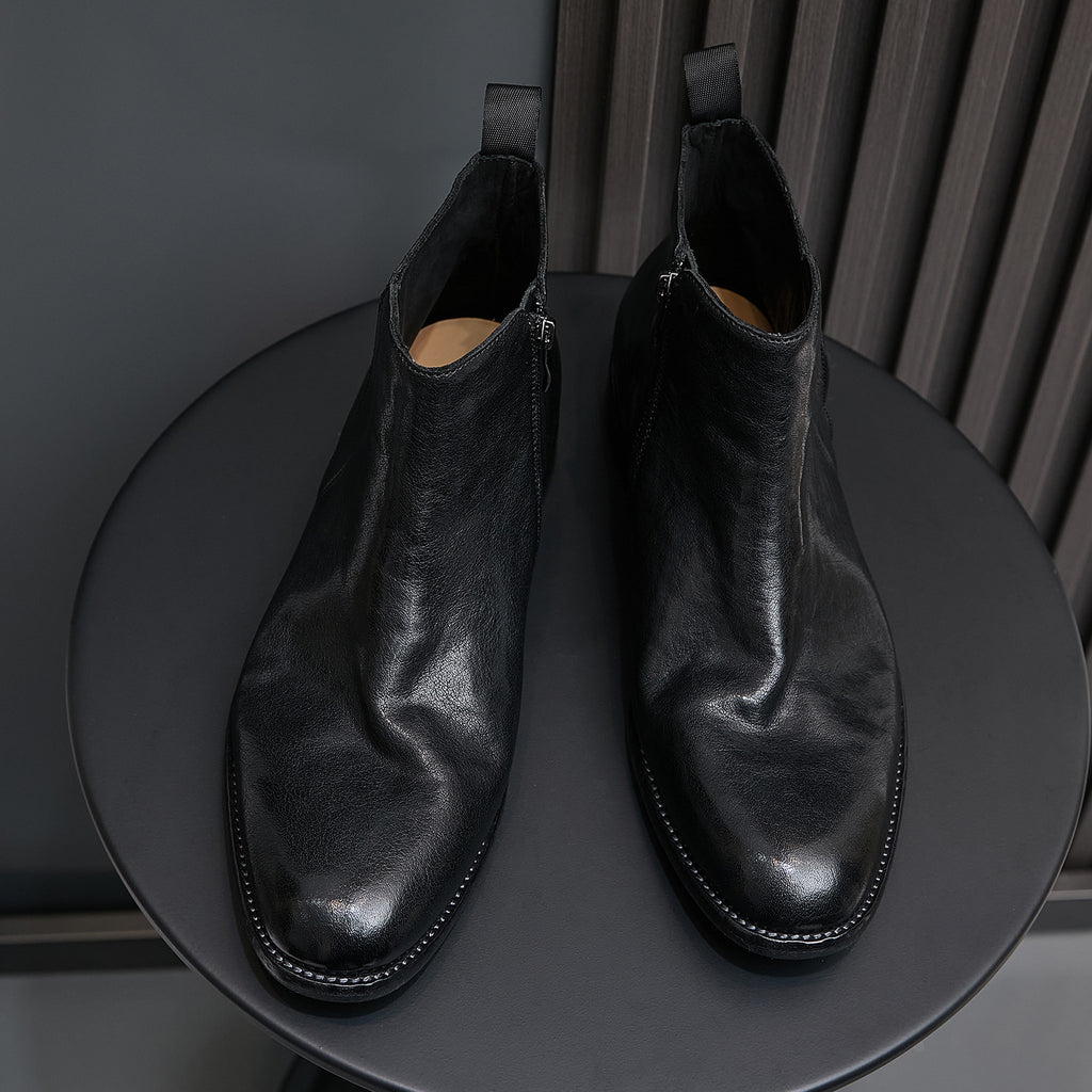 Pair of black leather side-zip pointed-toe ankle boots with stitched trim