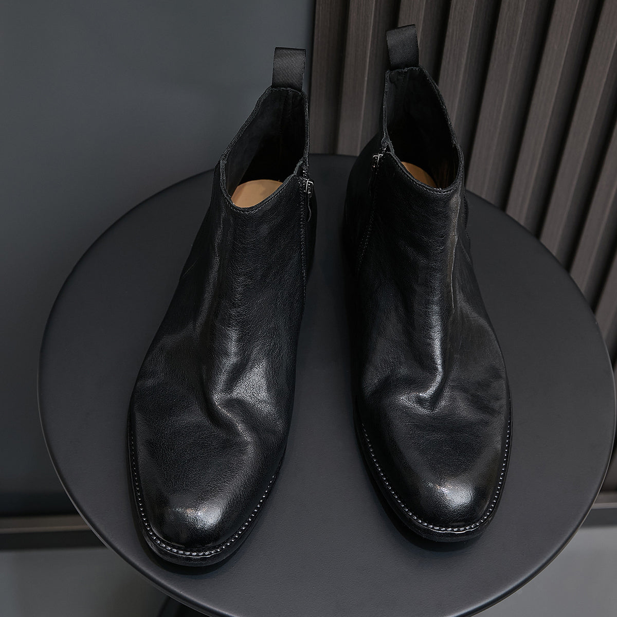 Pair of black leather side-zip pointed-toe ankle boots with stitched trim