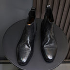Black pointed-toe Chelsea dress boots with stitched detailing and elastic gore