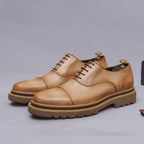 Tan lace-up oxford shoes with brogue stitching and chunky lug sole platform.