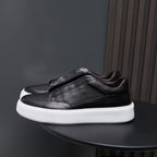 Black genuine leather low-top sneakers with minimalist side panels and white rubber sole