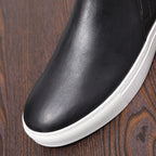 Men's point-toe leather side-zip dress boot, close-up of black leather upper and white sole