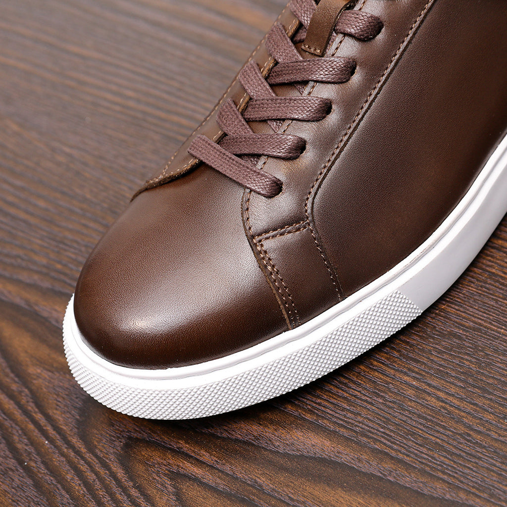 Men's dark brown leather lace-up sneaker, close-up of stitched toe and white sole