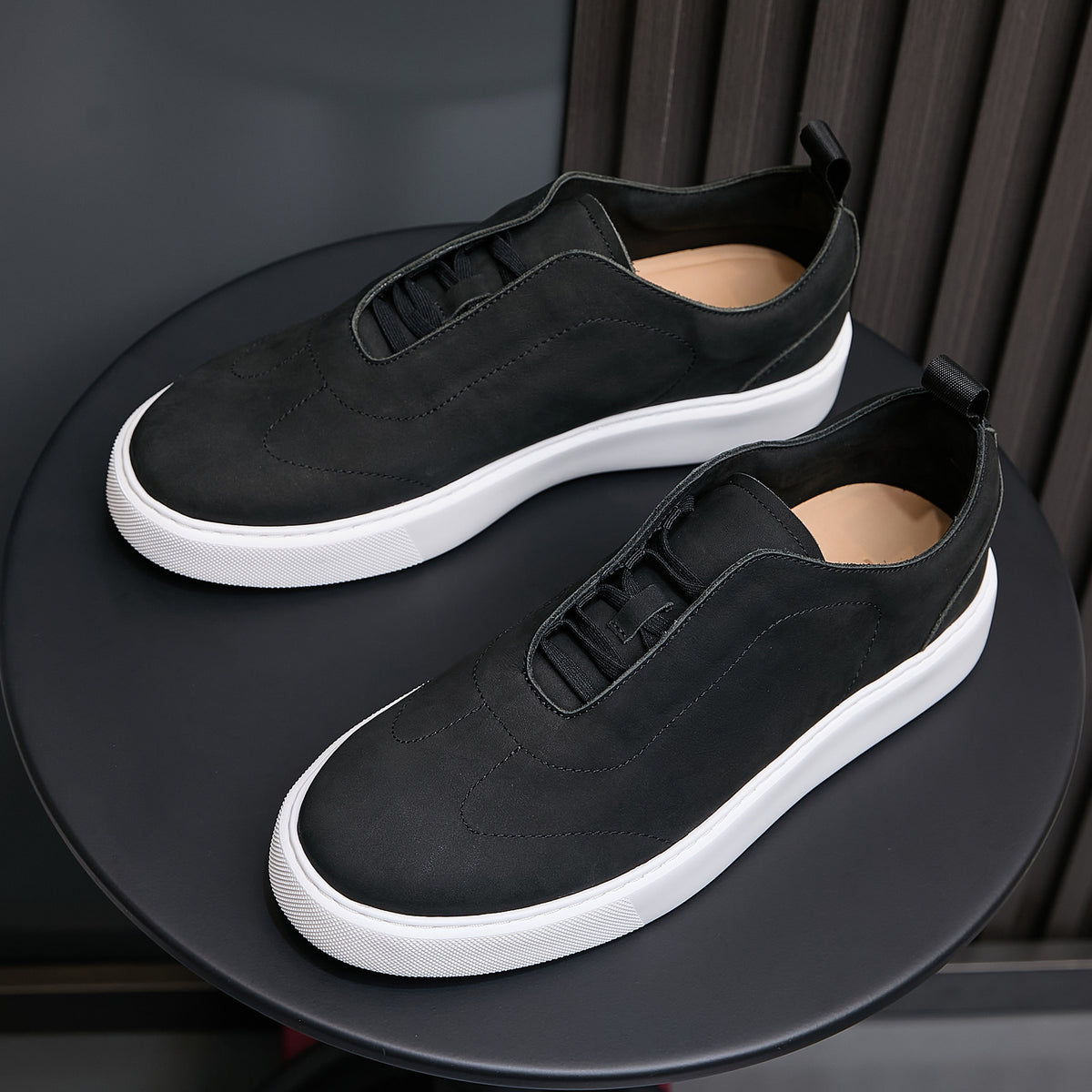 Men's black leather sneakers with lace-up vamp and white rubber sole.