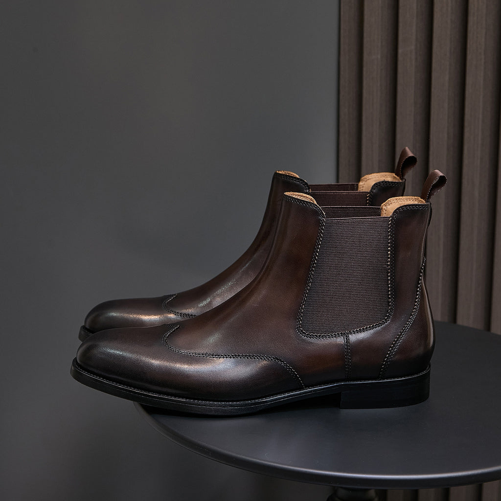 Men's pointed-toe Chelsea dress boots in dark brown, front three-quarter view