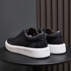 Black leather sneakers, rear view with padded collar and white midsole