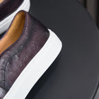 Dark leather sneaker with white sole edge and tan inner lining detail