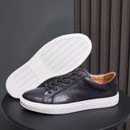 Black leather sneaker showing white treaded outsole with lace-up upper