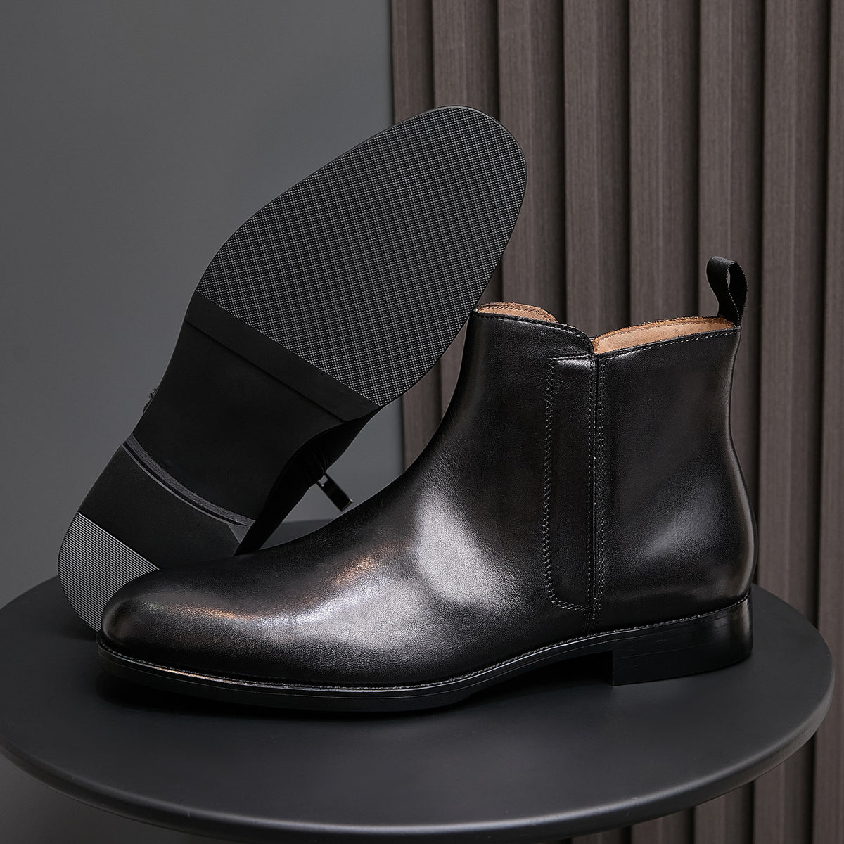 Black leather side-zip dress boots with pointed toe and stacked heel, side view
