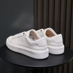 Pair of white leather low-top sneakers with heel tab and padded collar