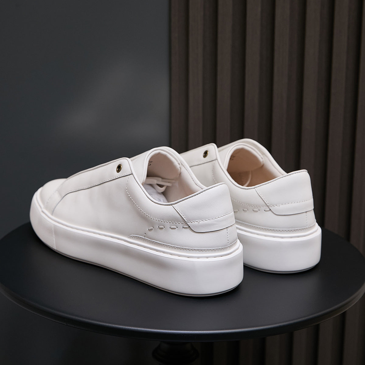 Pair of white leather low-top sneakers with heel tab and padded collar