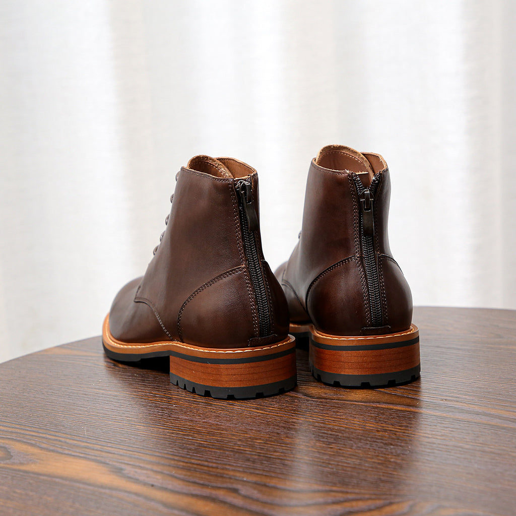 Pair of dark brown leather side-zip ankle boots with lace-up design and orange sole