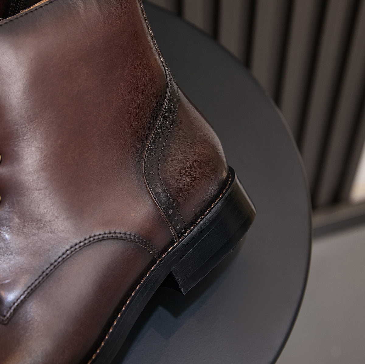 Men's pointed-cap-toe leather dress boots, dark brown, side view and stitched welt