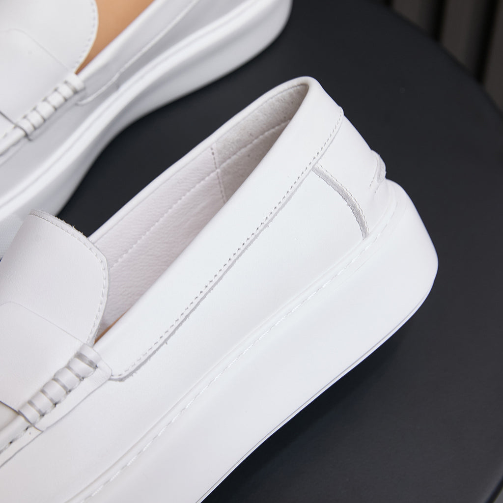 White leather slip-on sneakers with stitched side panels and padded collar