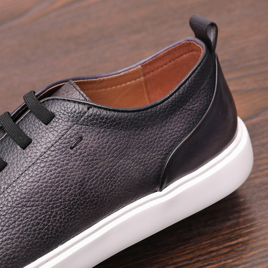 Black genuine leather sneaker with smooth side panel, contrast stitching, and white sole.