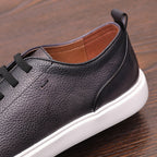 Black genuine leather sneaker with smooth side panel, contrast stitching, and white sole.