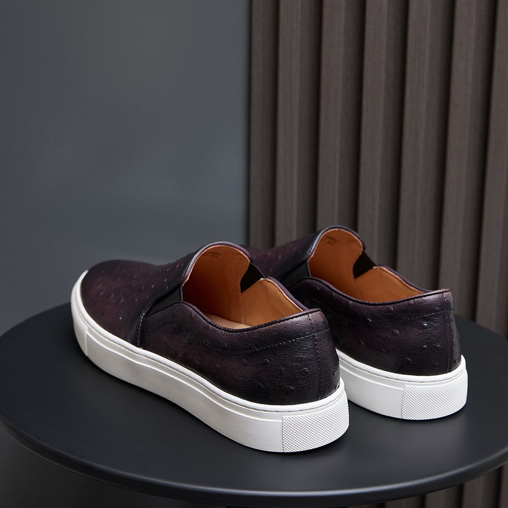 Pair of dark leather sneakers with white rubber soles and cushioned heel collars
