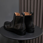 Black leather side-zip dress boots, pointed cap toe, heel and back view pair
