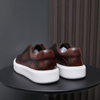 Brown leather sneakers viewed from the back with white platform sole