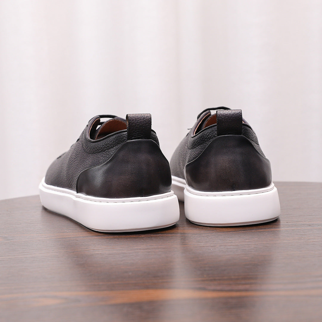 Pair of black genuine leather sneakers, back view with heel tab and white rubber soles.