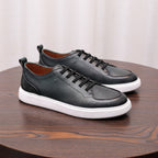 Pair of black genuine leather lace-up sneakers with white midsole and cushioned sole.